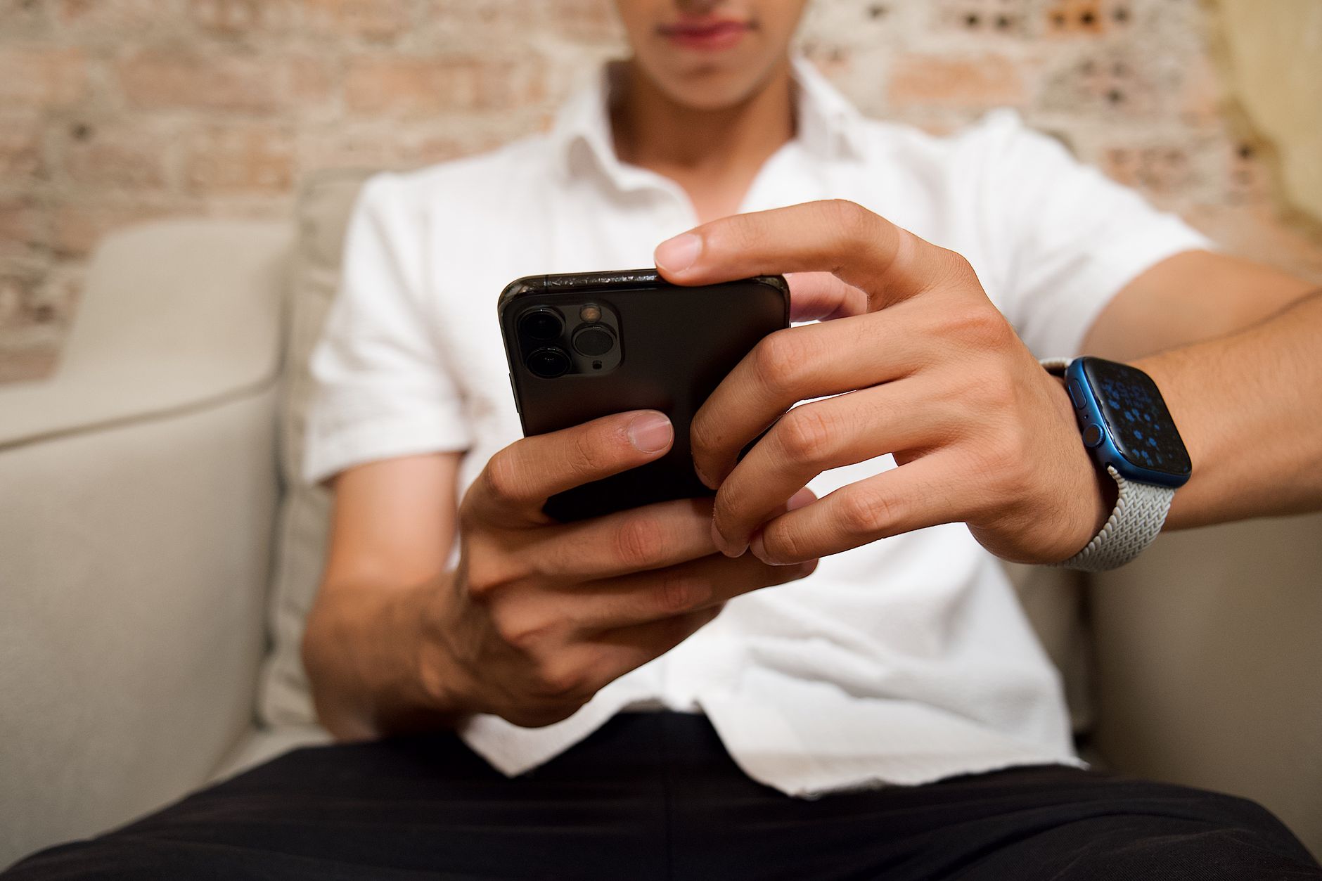 Pria sedang memeriksa daftar langganan di smartphone, menandai biaya tersembunyi