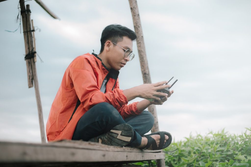 Orang Indonesia muda sedang mengecek anggaran keuangan di ponsel