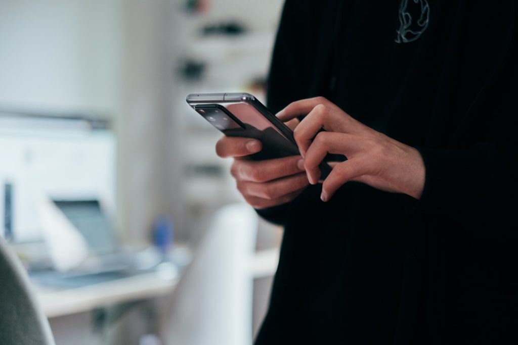 Orang menggunakan smartphone untuk cek saldo (ID)