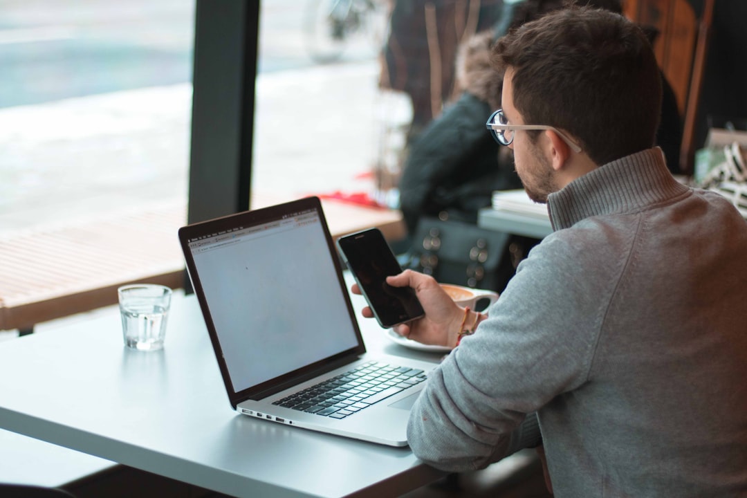 Mahasiswa di kafe sambil mengatur anggaran di laptop