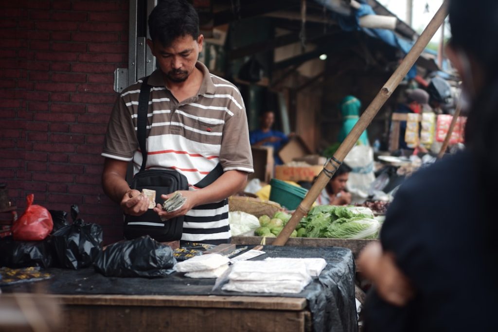 Pemilik warung pasar kecil menghitung uang tunai