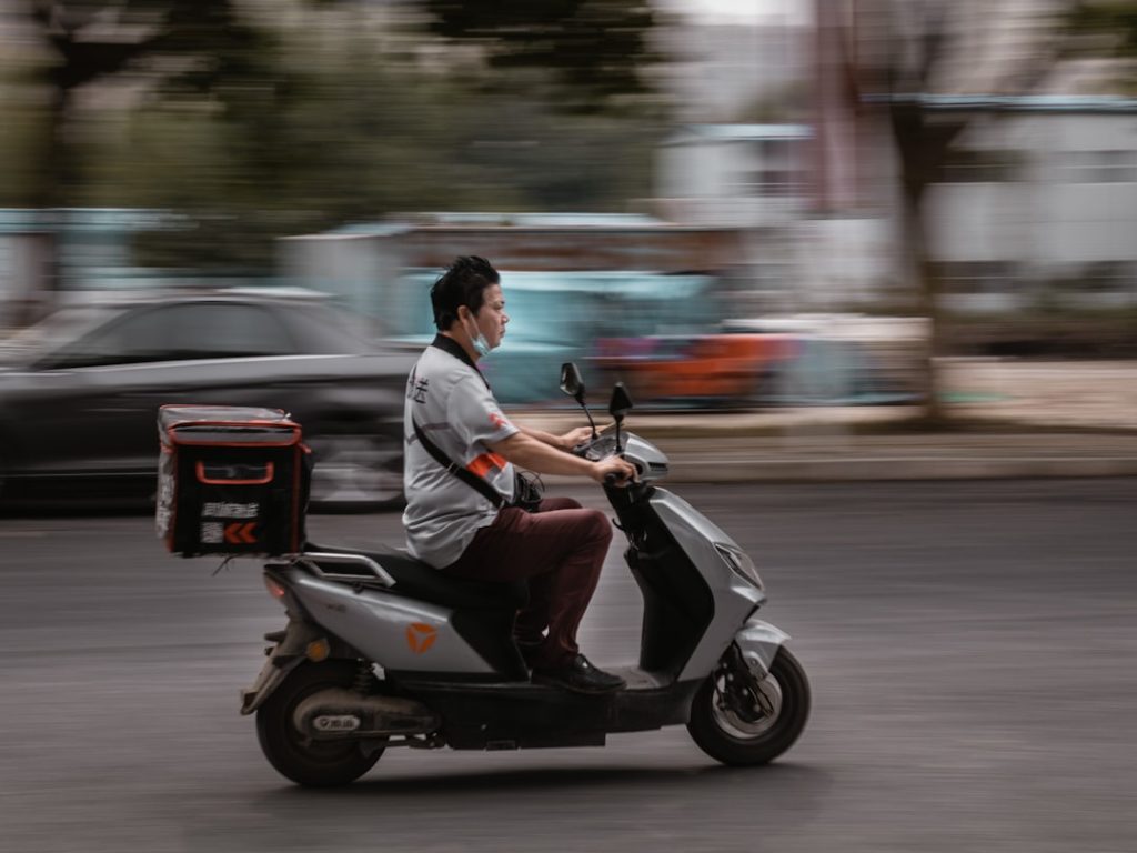 Pengantar ojek online sedang mengendarai motor