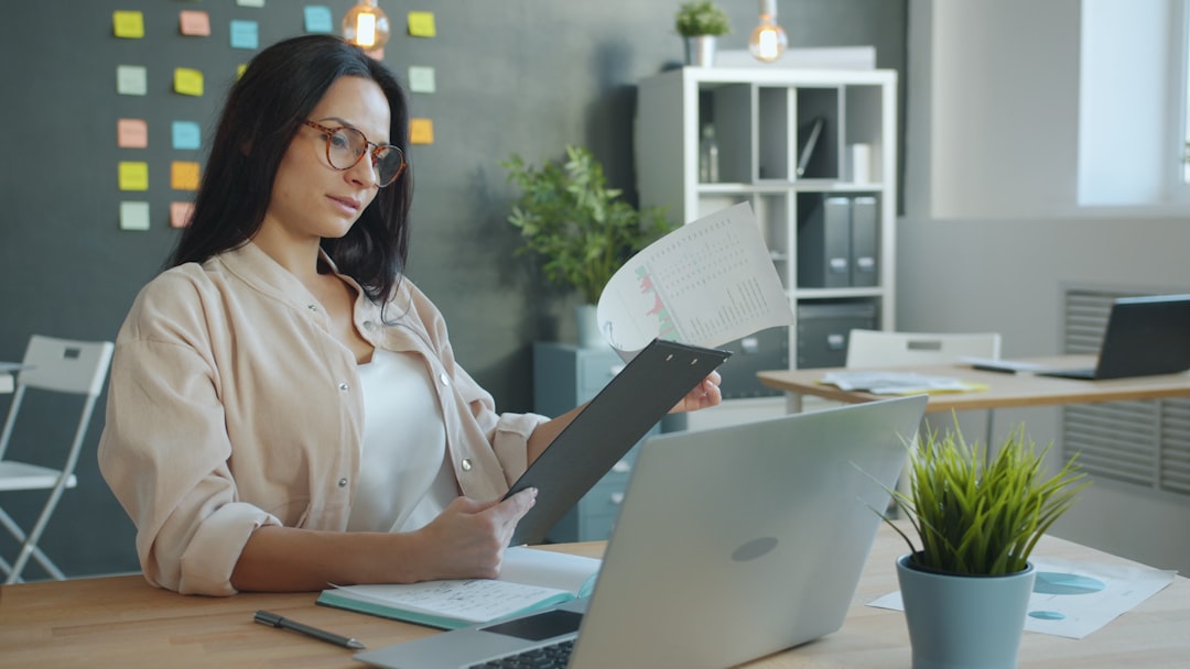 Wanita memeriksa spreadsheet anggaran bulanan di laptop
