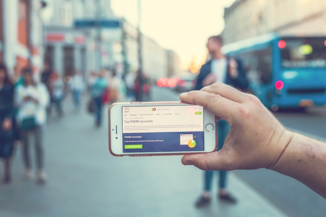 Tangan memegang smartphone dengan aplikasi pembayaran