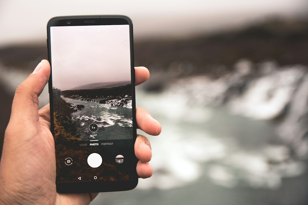 Tangan memegang smartphone dengan layar kunci