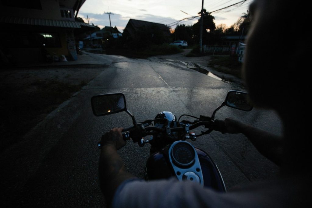 Pengemudi ojol memeriksa ponsel di jalan